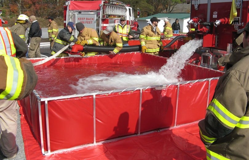 Fire fighters using their folding frame water tank to shuttle water where it is needed most