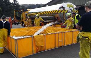 Firemen filling a Husky folding frame tank
