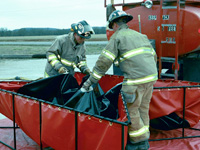 Firefighters folding up a Husky tank