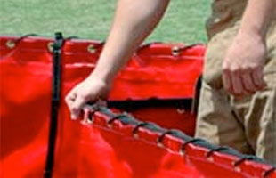 Firefighter folding up a folding frame tank